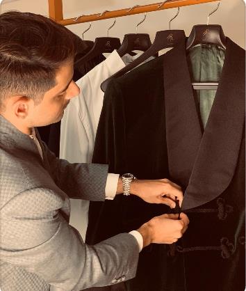 Rishabh Manocha buttoning suit jacket