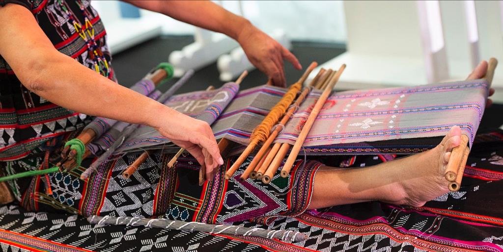Women using a backstrap loom to weave a traditional Mexican textile